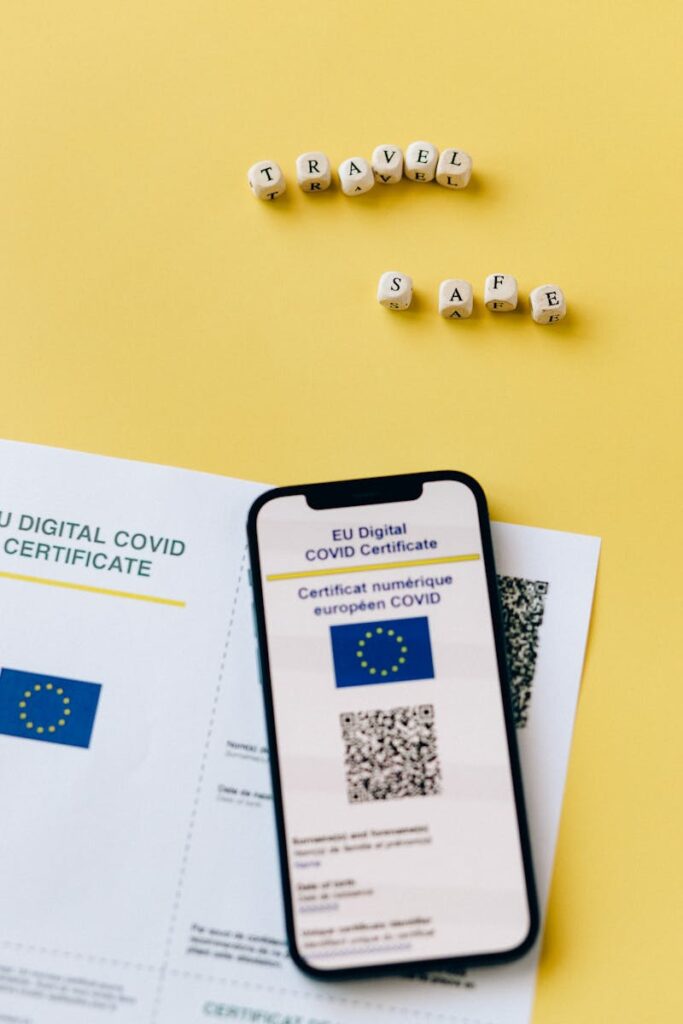 EU Digital COVID certificate with phone on yellow backdrop symbolizes travel safety.