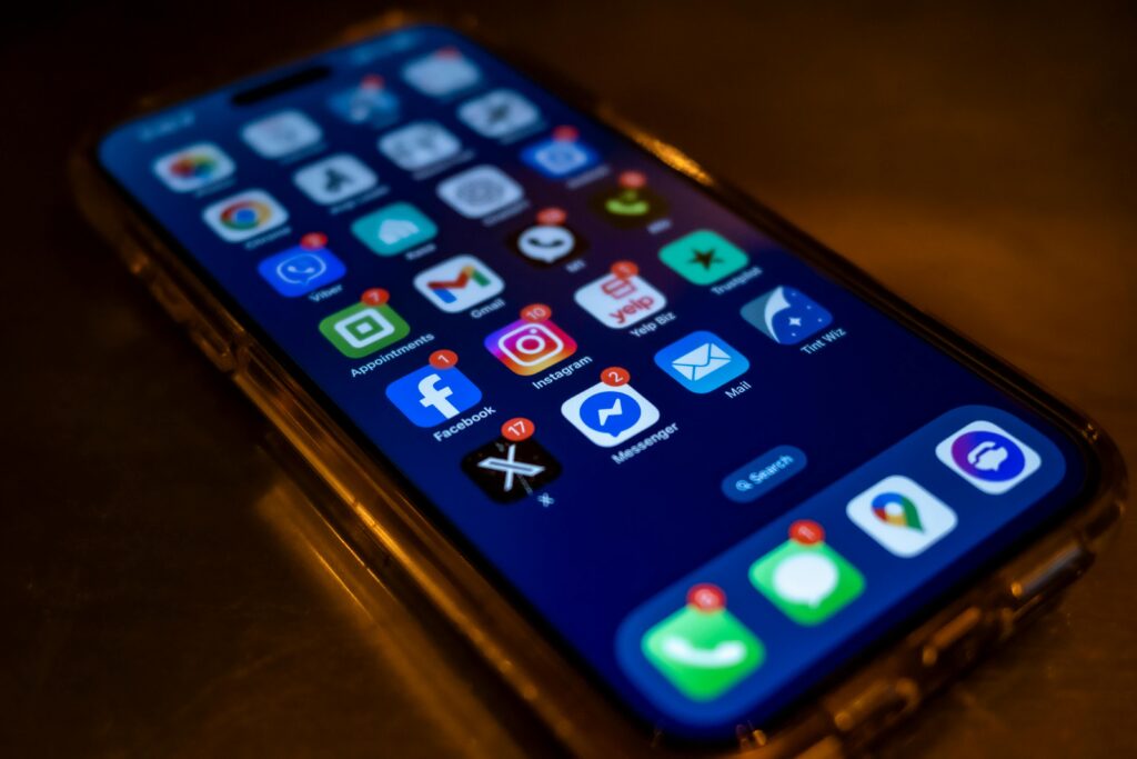 Smartphone screen displaying social media app notifications in a dimly lit setting.