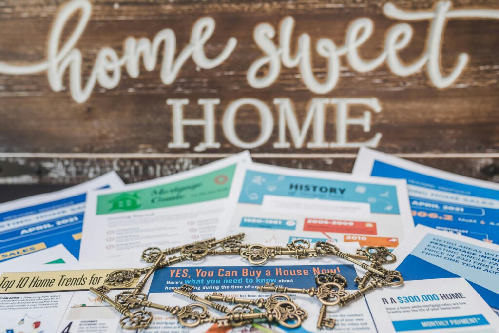 A conceptual image of real estate trends with keys and documents in front of a 'Home Sweet Home' sign.