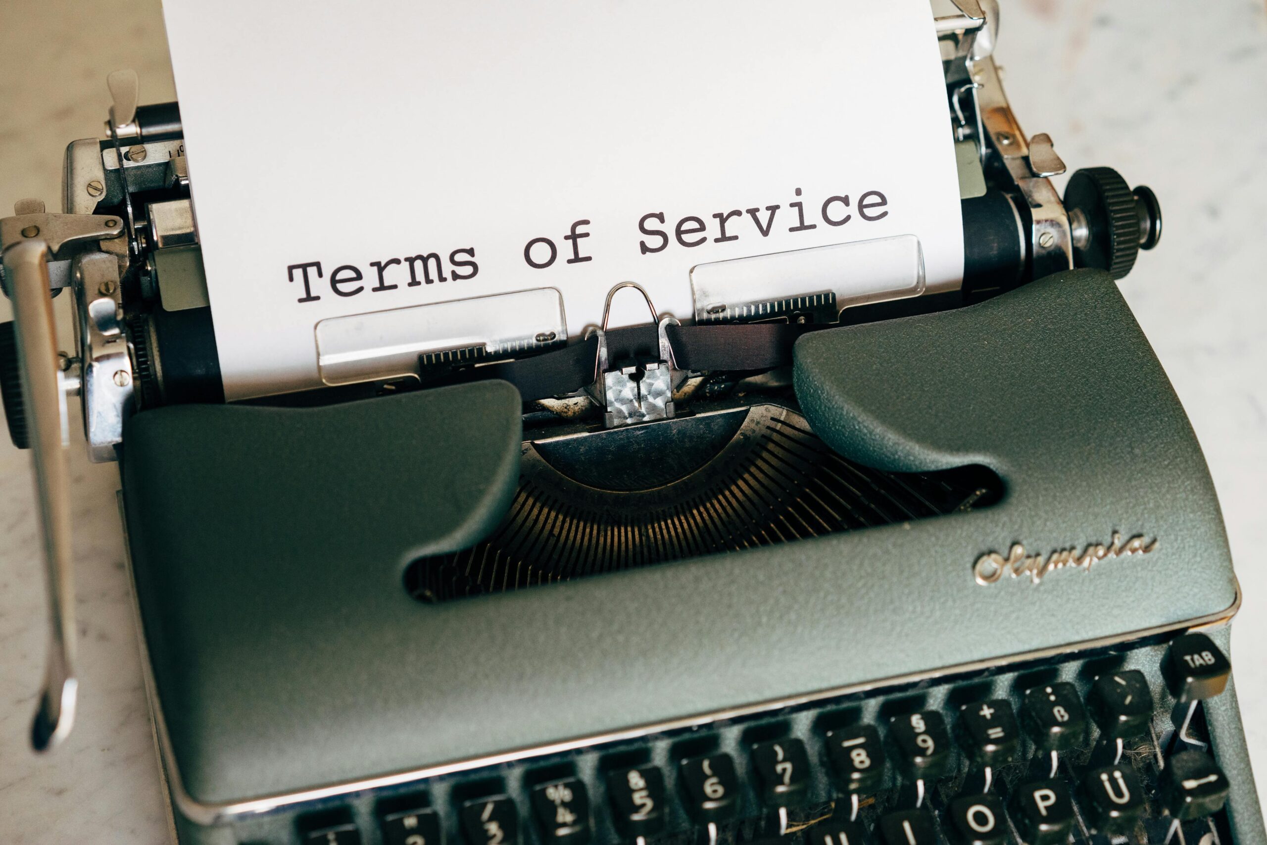 Terms of SERVISE Close-up of a vintage typewriter printing 'Terms of Service' on paper, ideal for legal and business themes.