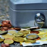 Close-up of a secure cash box with euro coins and banknotes, symbolizing wealth and financial security.