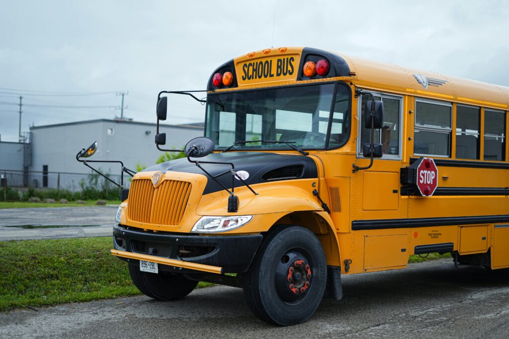Yellow school bus parked outdoors in Kitchener, Ontario, under cloudy skies.
