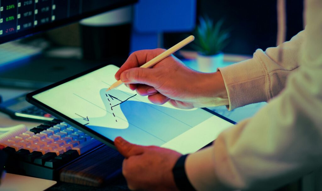 Hand-drawn business graph on a tablet with stylus in a modern workspace setting.
