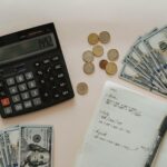 Flat lay of calculator, cash, coins, and handwritten notes for budget planning.