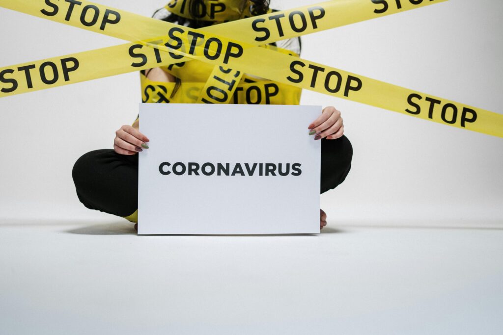 Conceptual image of coronavirus awareness with caution tape and a sign.